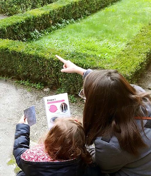 Mère et sa fille, de dos, avec le livret découverte du Couvent des Jacobins